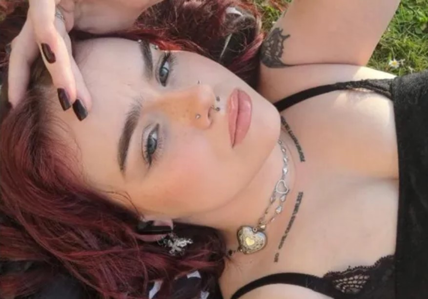 a woman with red hair is laying down with her hand on her head