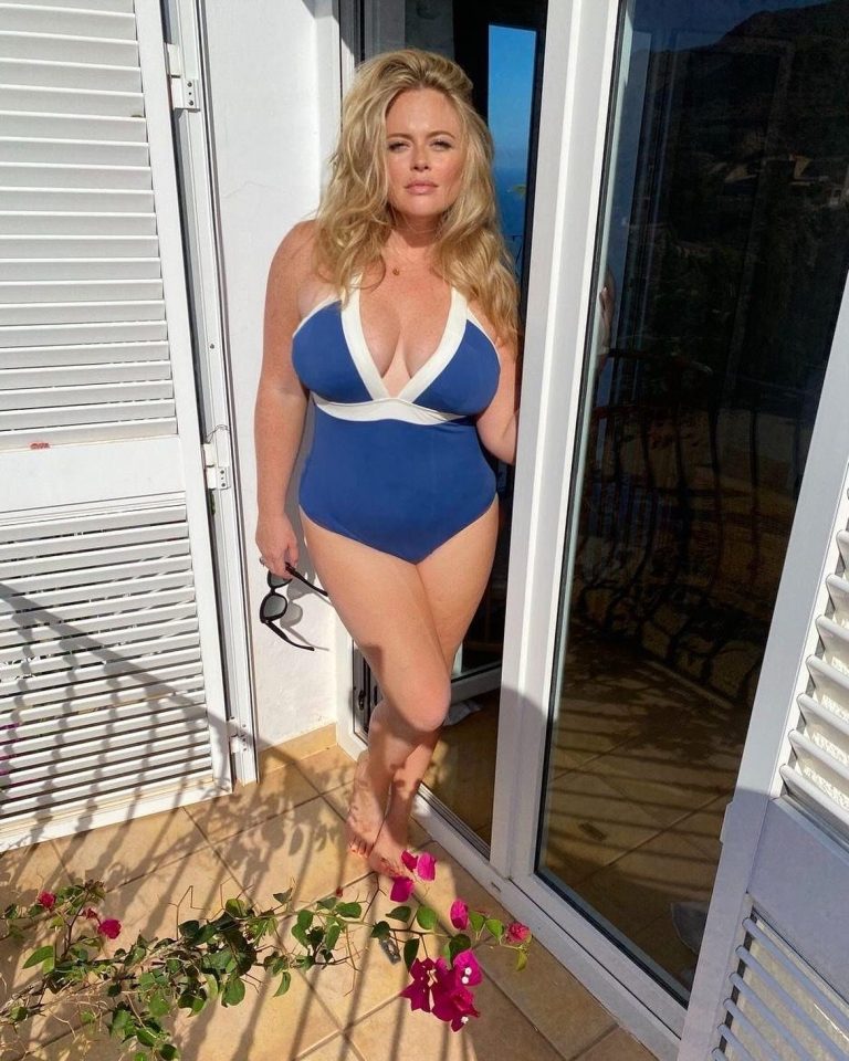 a woman in a blue swimsuit is standing in a doorway