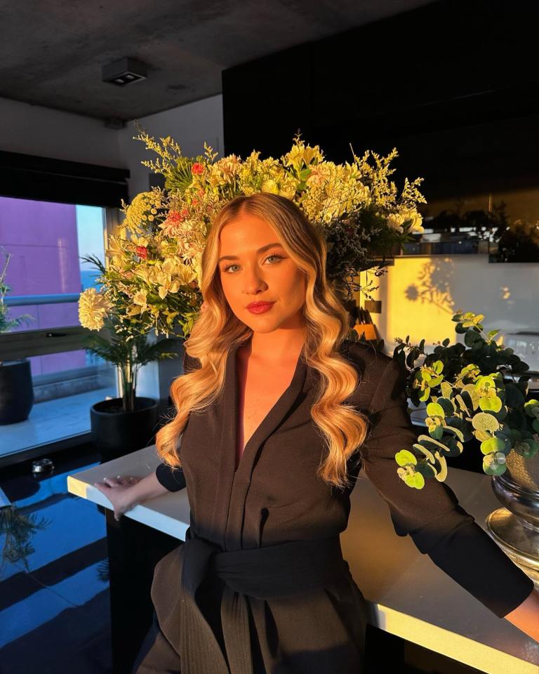 a woman in a black dress with flowers in her hair