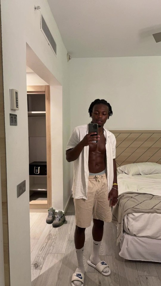 a shirtless man taking a picture of himself in a hotel room