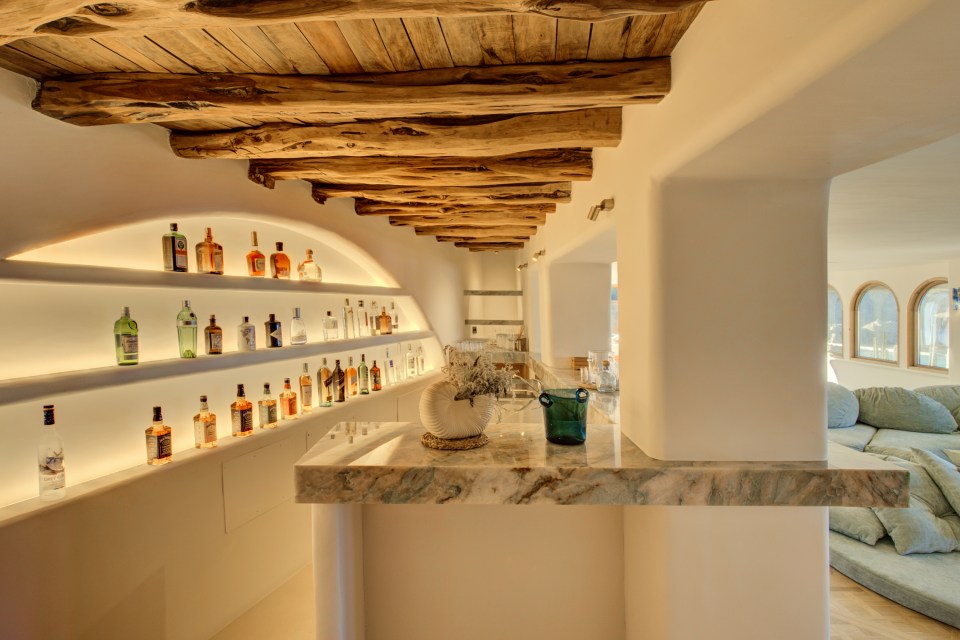 several bottles of liquor are lined up on a shelf including a bottle of martini