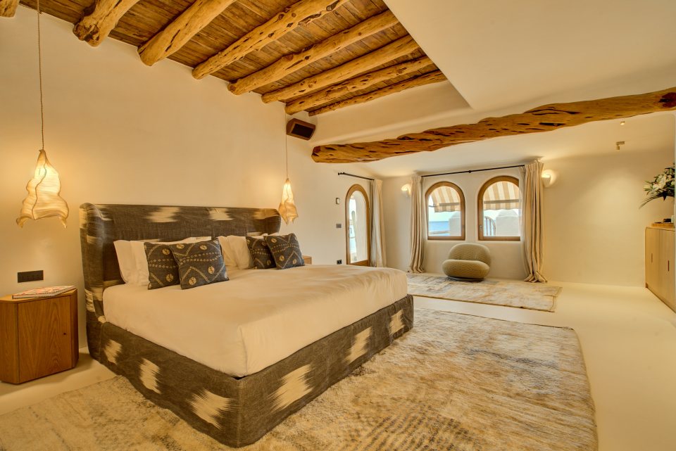 a bedroom with a large bed and a chair