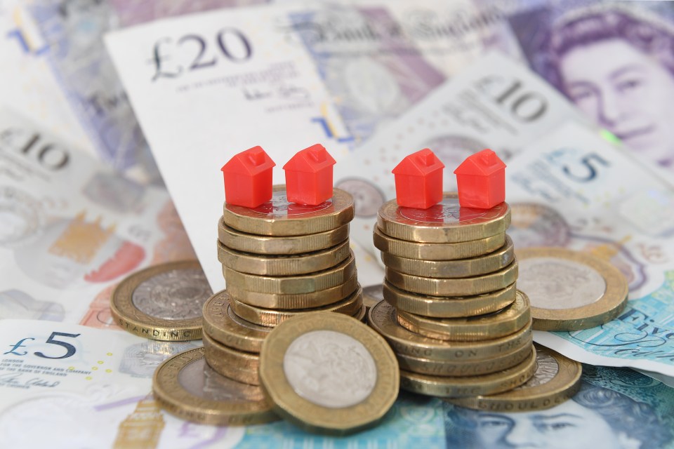a stack of coins sits on top of a stack of twenty pound notes