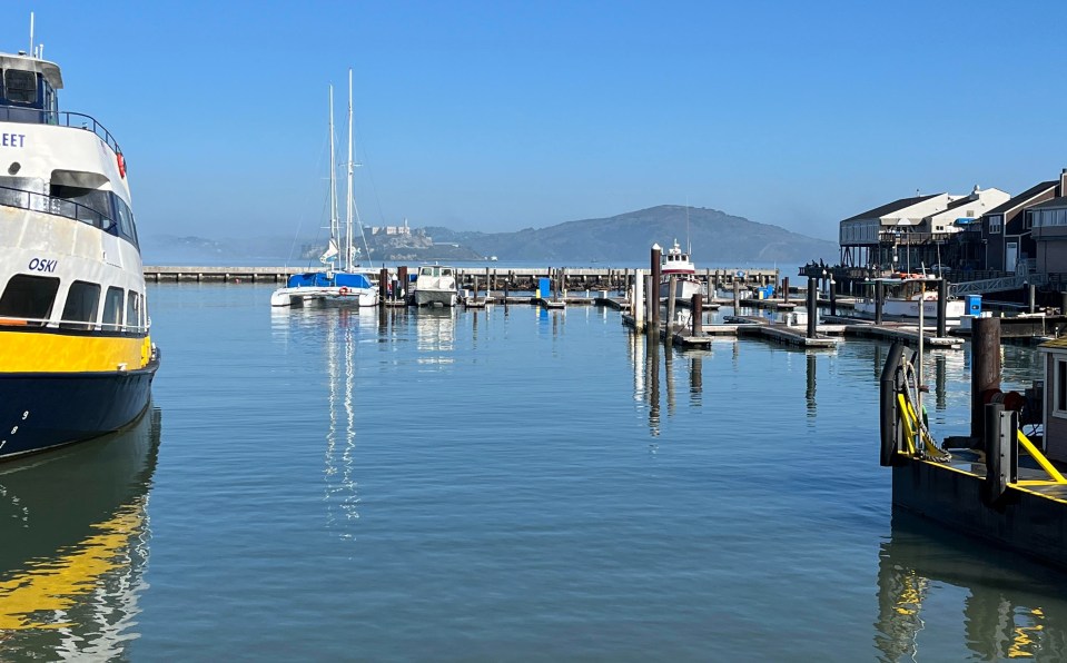 a blue and yellow ferry is docked in a harbor