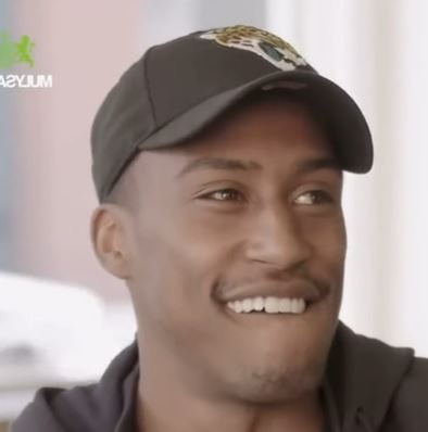 a close up of a man wearing a baseball cap and smiling .