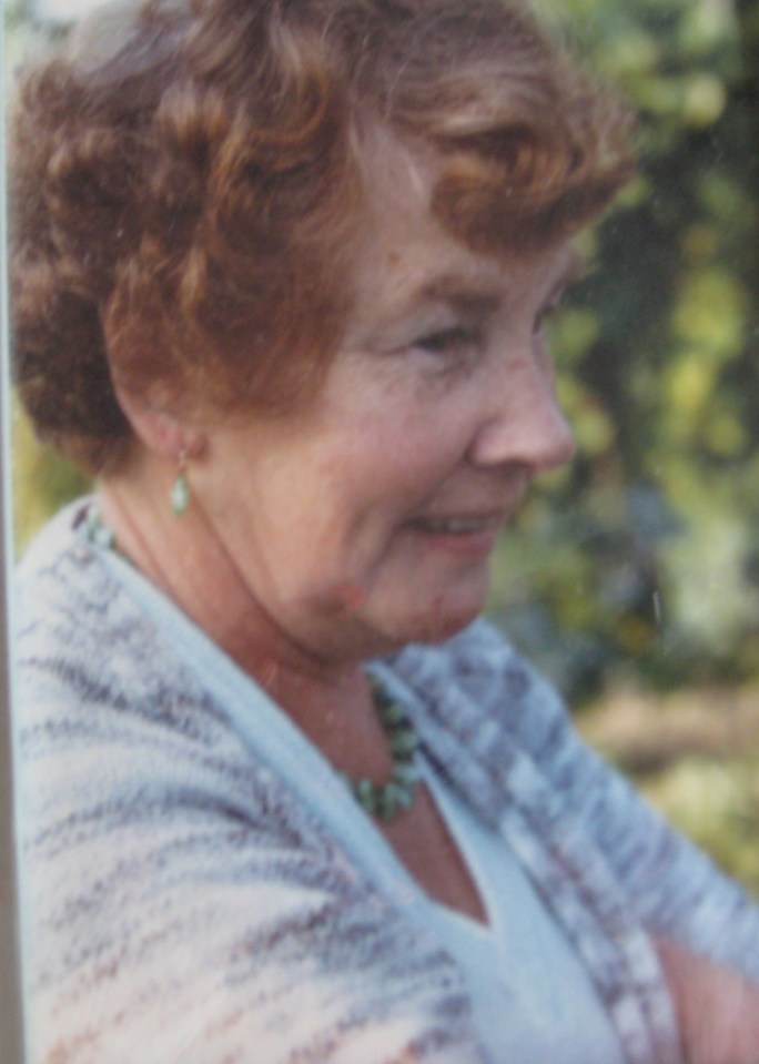 a woman with red hair is wearing a necklace and earrings
