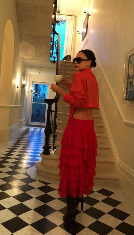 a woman in a red skirt is standing on a set of stairs