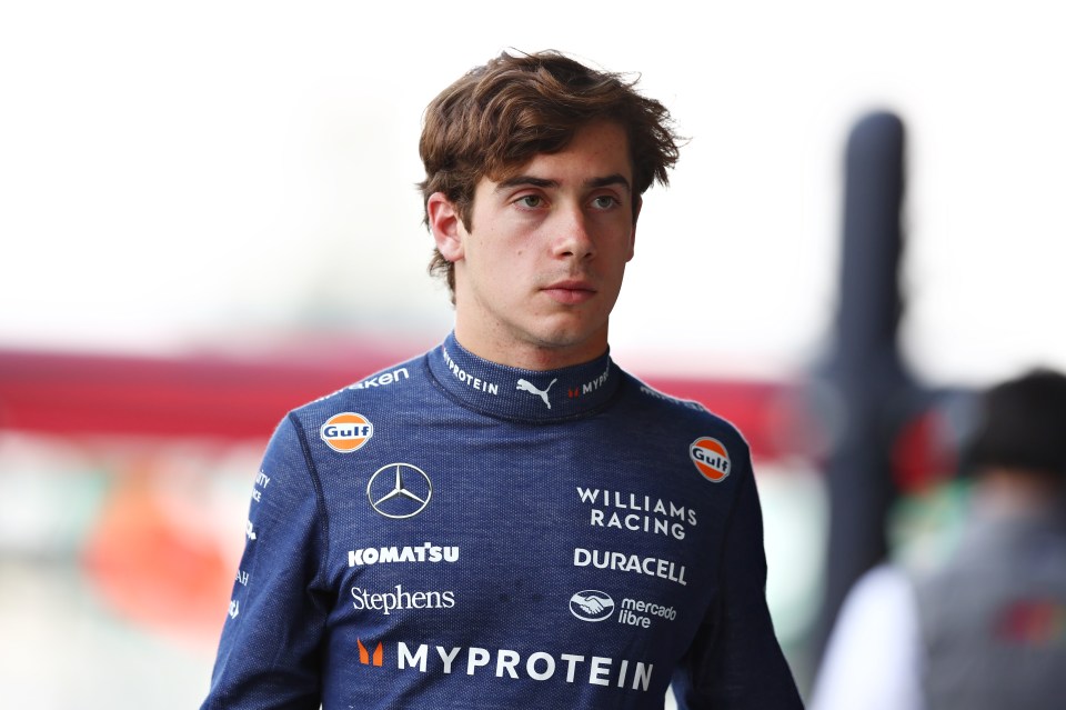 a young man wearing a williams racing uniform