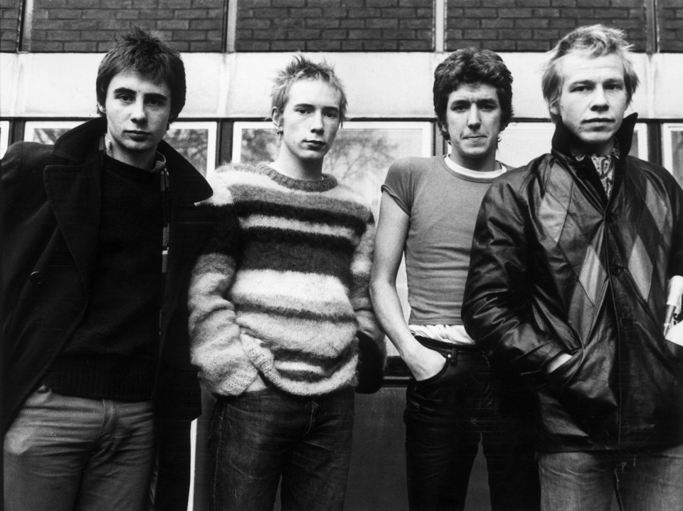 a group of men standing next to each other with their hands in their pockets