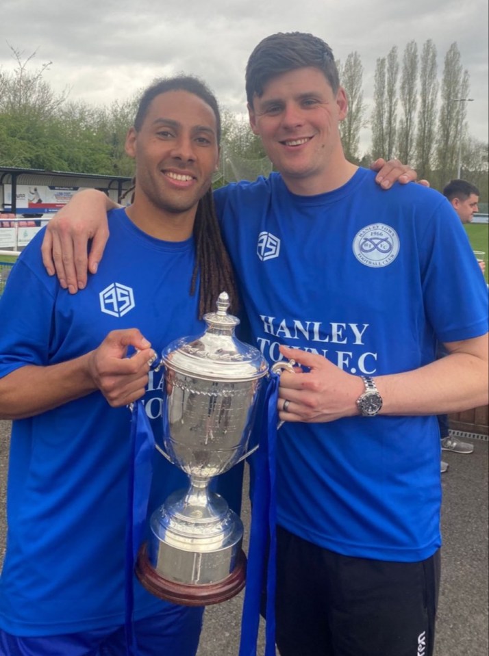 two men in blue shirts that say banley holding a trophy