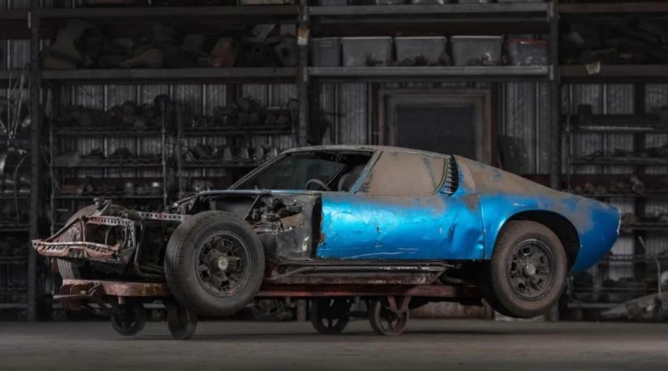 a blue car is sitting on a cart in a garage