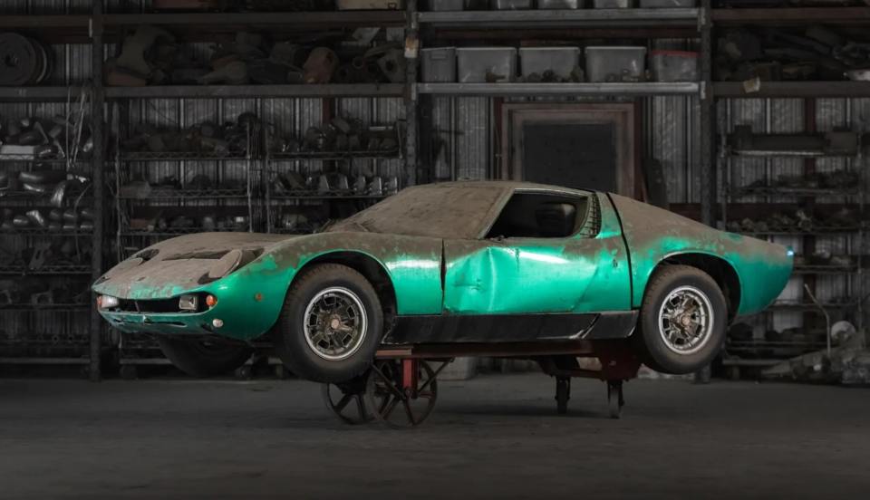 a green car is sitting on a cart in a garage