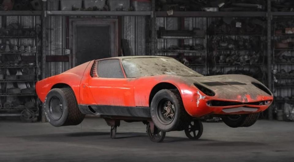 a red car with a tire that says goodyear on it