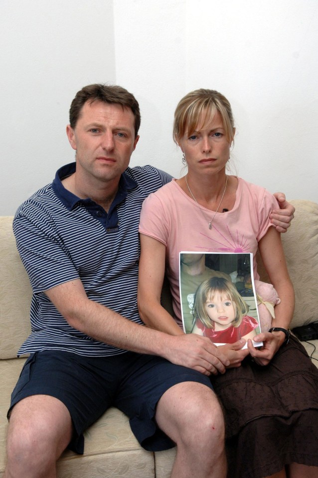 a man and woman sit on a couch holding a picture of a little girl