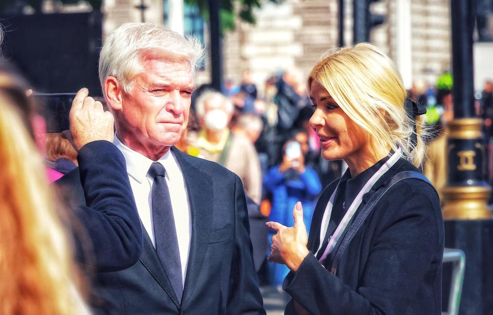a man in a suit and tie is being photographed by a woman