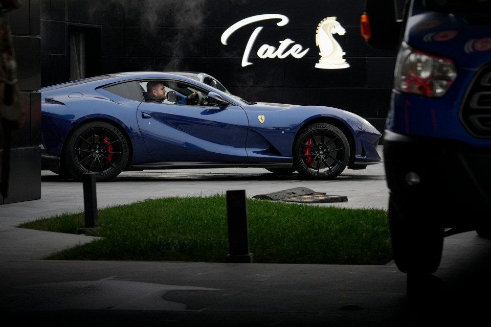 a blue sports car is parked in front of tate 's
