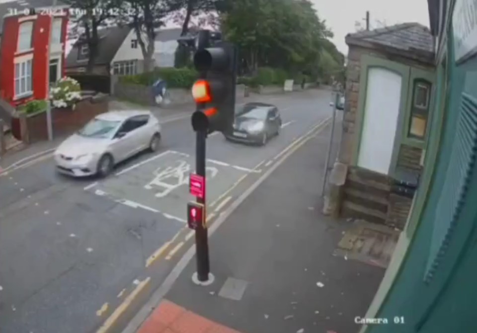 a car is driving down a street with a sign that says camera 01
