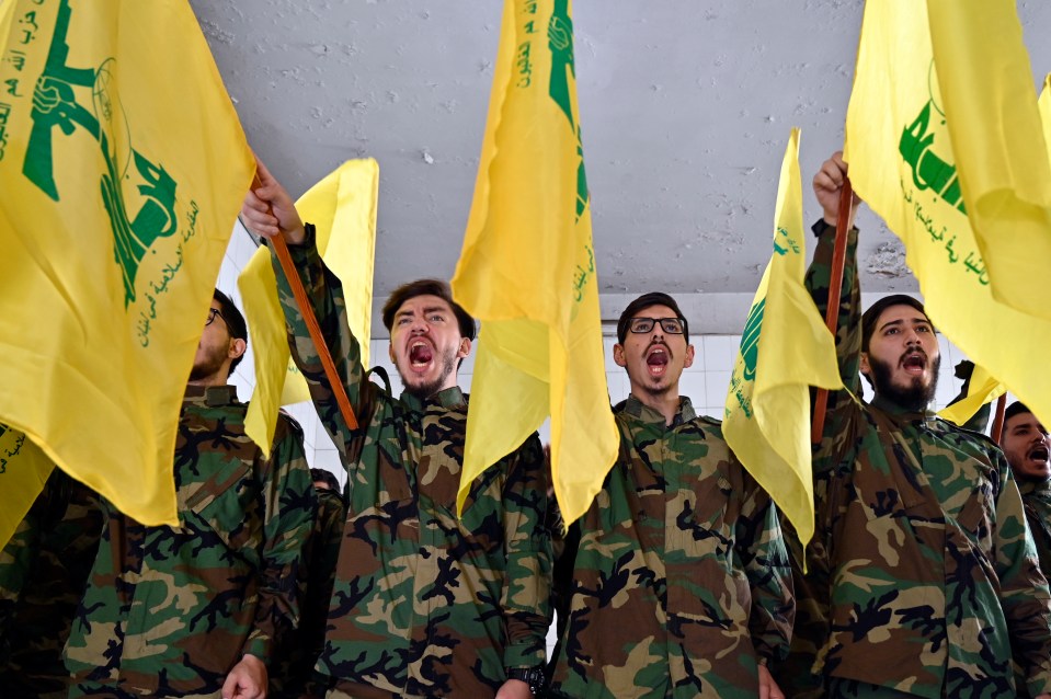a group of soldiers holding up yellow flags with arabic writing on them