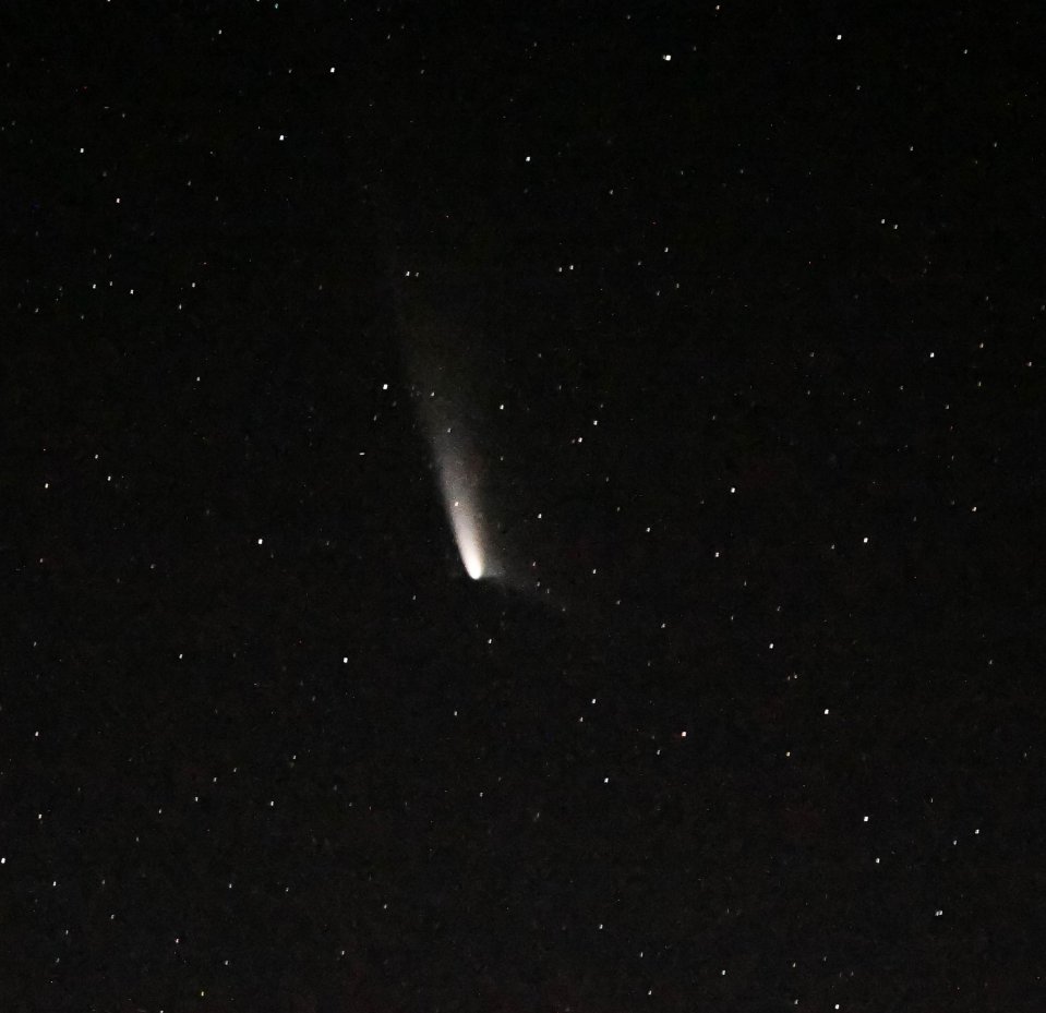 a comets tail is visible in the night sky