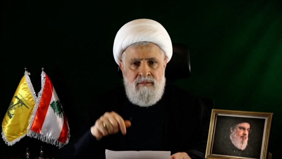a man sitting in front of a picture of a man with a beard
