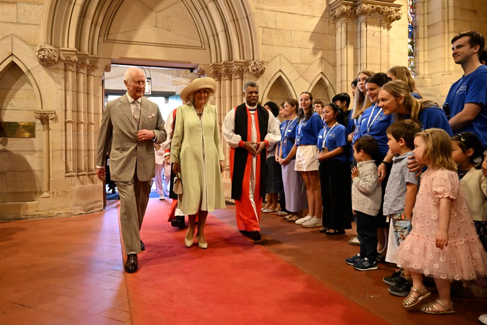 a man and woman walking down a red carpet in a church
