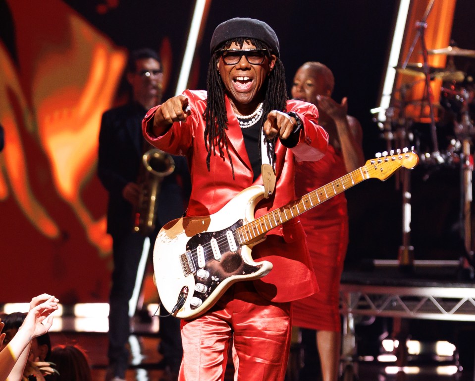 a man in a red suit is playing a guitar