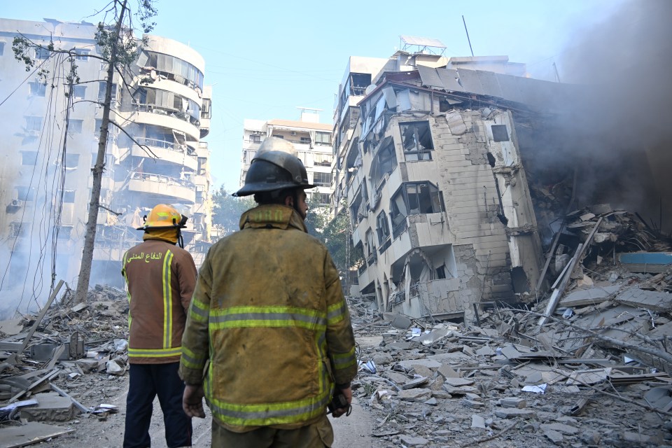 Rescue teams after an airstrike in Beirut as smoke billows in the air