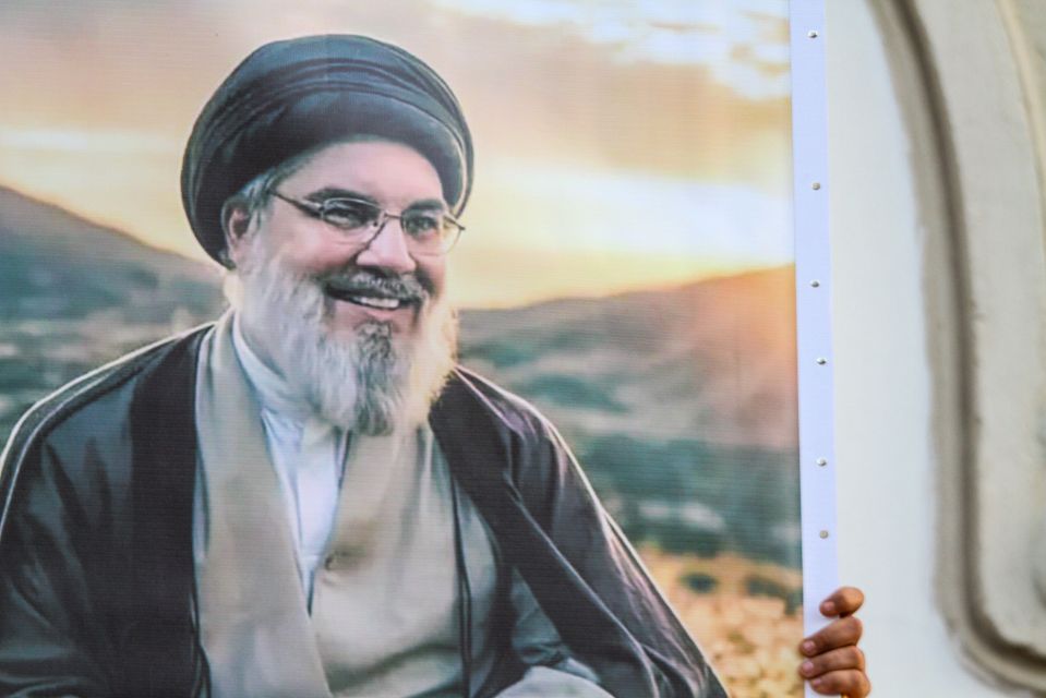 a man with glasses and a beard is smiling
