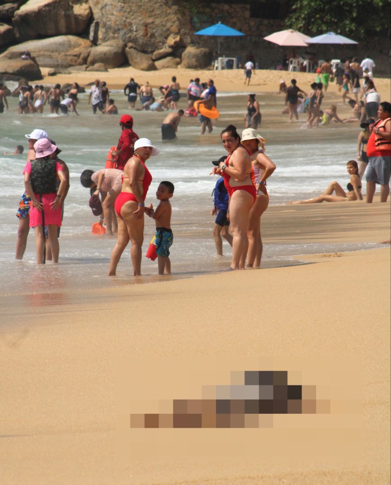 a woman in a red bikini stands next to a boy on a beach