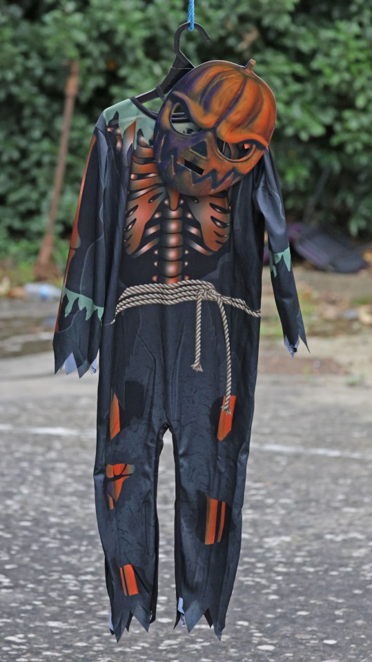 a child 's halloween costume is hanging on a clothes line