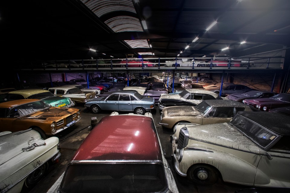 a bunch of old cars are lined up in a garage