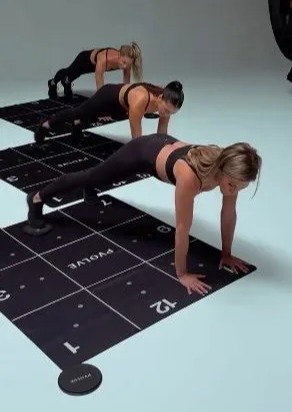 three women are doing push ups on a mat .