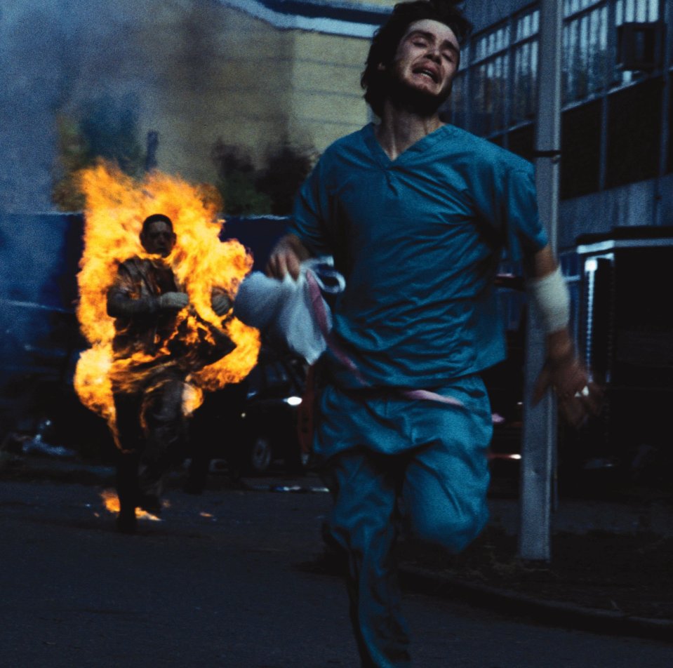 a man in scrubs is running from a fire
