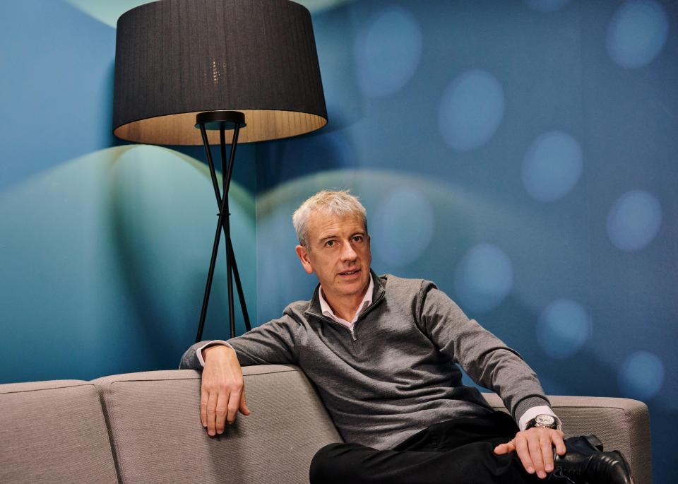 a man sits on a couch in front of a lamp