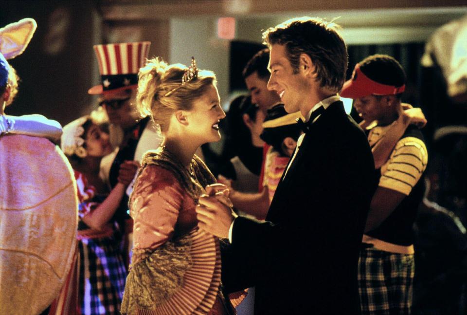 a man in a tuxedo is dancing with a woman in a pink dress