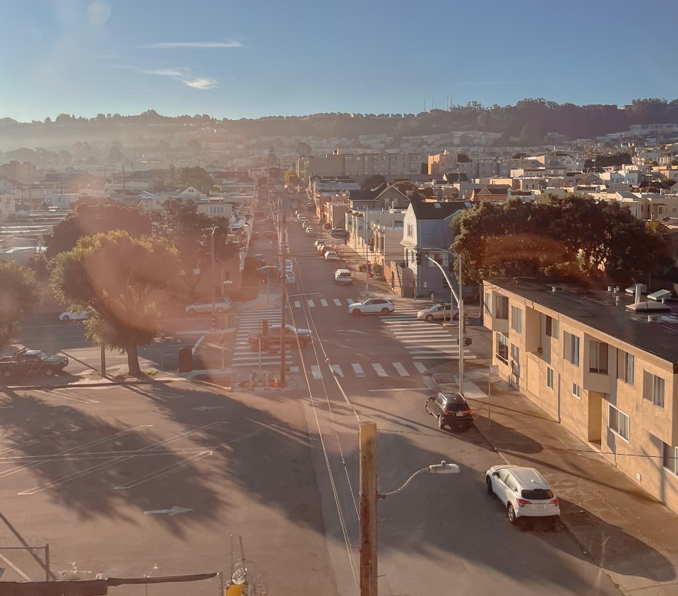 an aerial view of a city street with cars driving down it