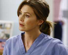 a woman in a blue scrub top has her hair in a ponytail