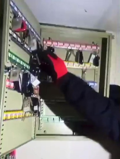 a person in a red hat is reaching into a key cabinet .