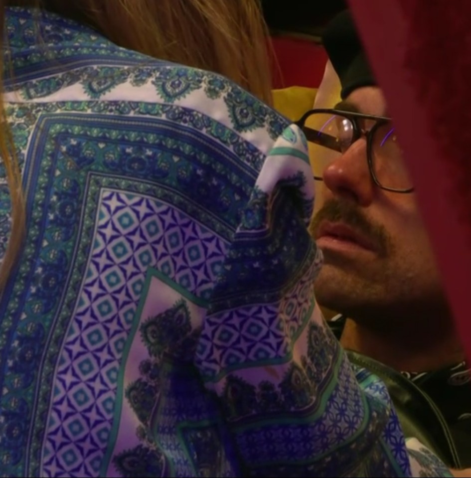 a man wearing glasses looks at a woman in a blue and white shirt