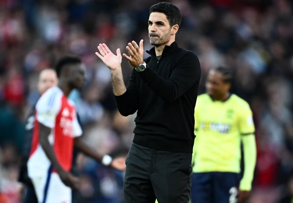 a man with a watch on his wrist applauds during a soccer game
