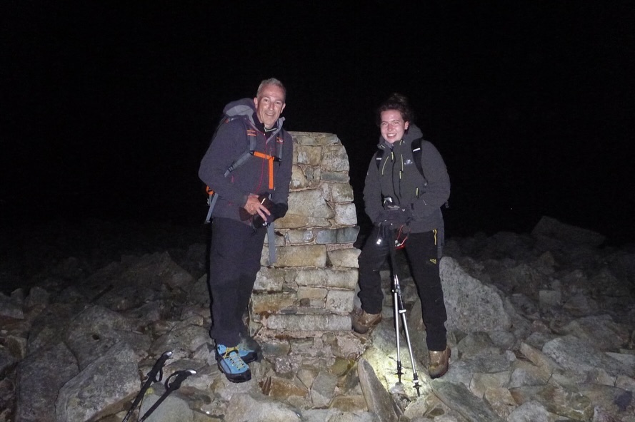 a man and a woman standing on top of a rocky hill
