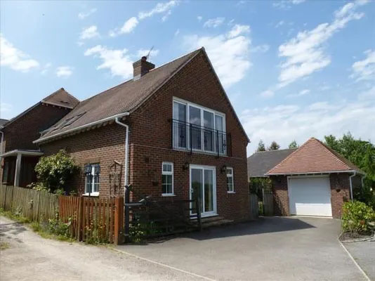 a large brick house with a garage and a balcony .