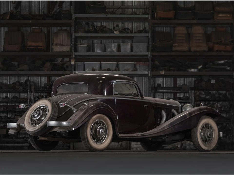 a very old car is parked in a garage