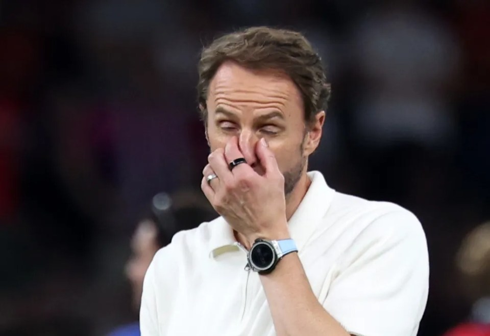 a man covering his nose with his hand while wearing a watch