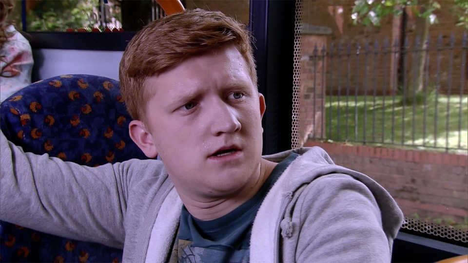 a young man with red hair is sitting on a bus