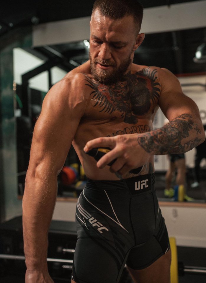 a man with a tattoo on his chest is wearing a pair of ufc shorts