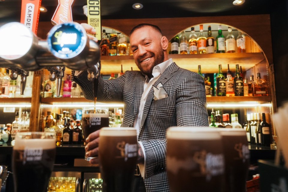 a man in a suit is pouring beer from a tap that says camden