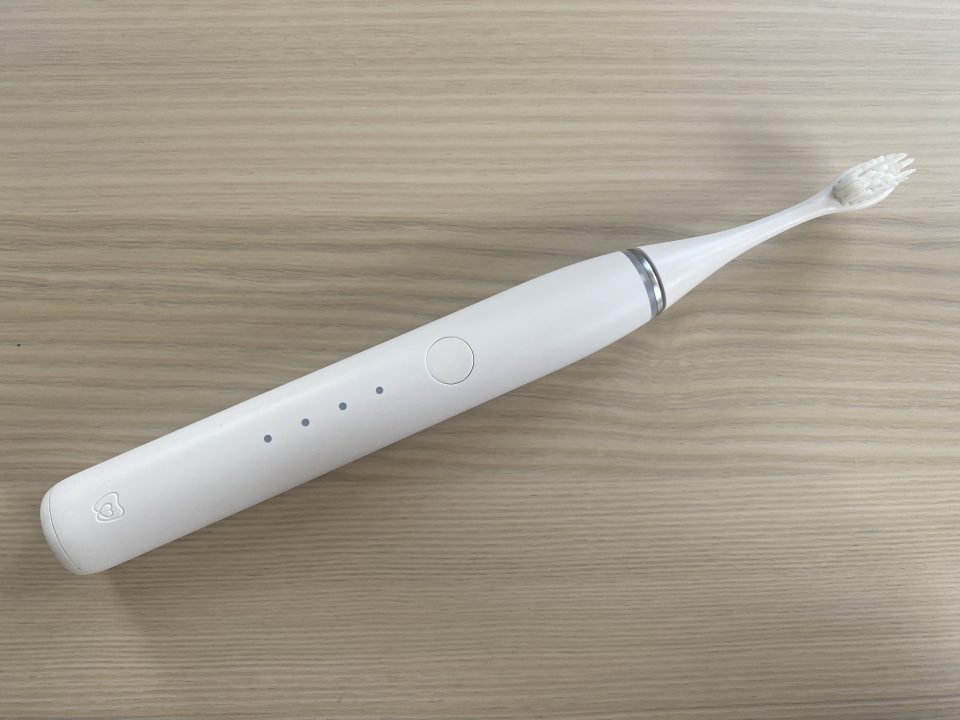 a white electric toothbrush is sitting on a wooden table