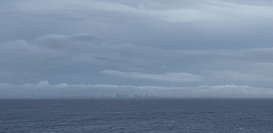 a large body of water with a city in the distance