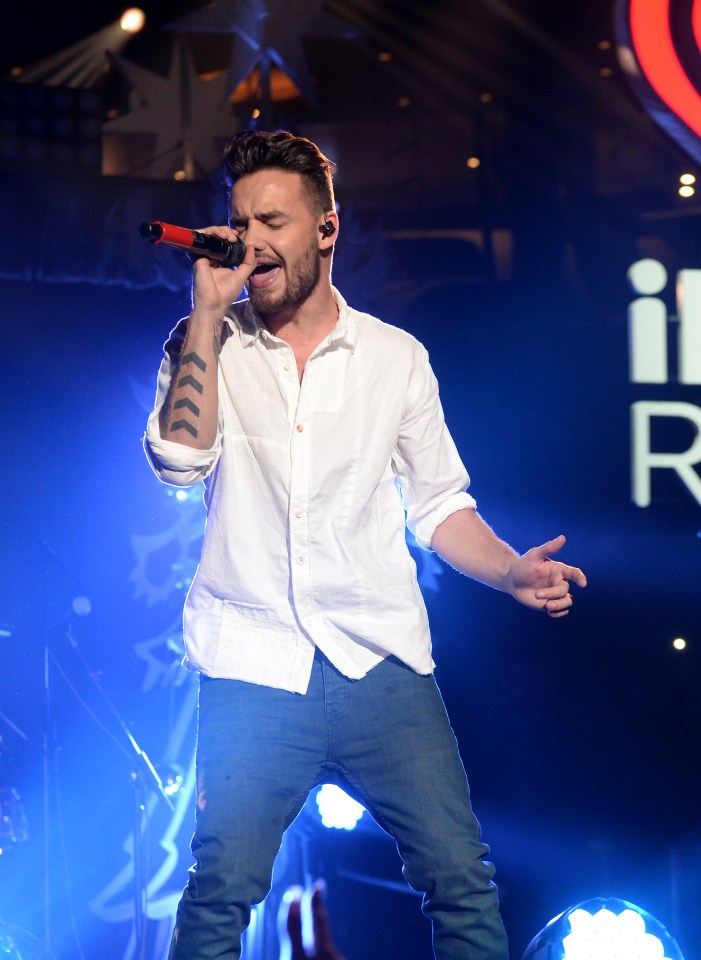 a man with a tattoo on his arm singing into a microphone